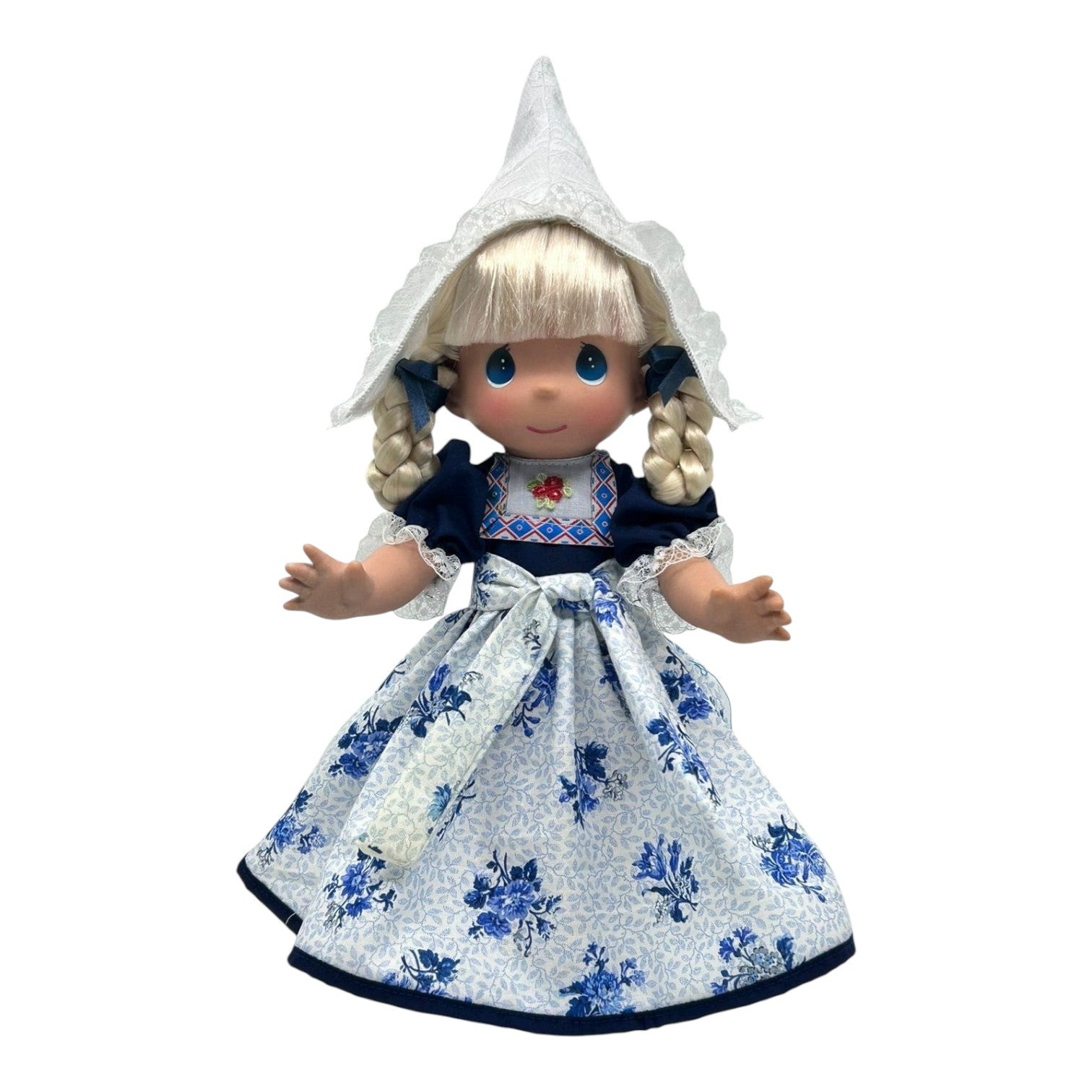 The Doll Maker 12-inch Holland vinyl doll wearing a traditional Dutch costume with a white lace cap and floral dress.