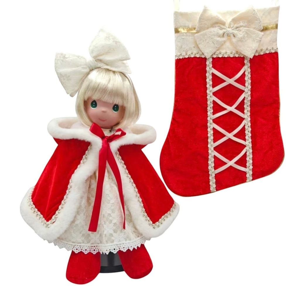 The Doll Maker 2026 Precious Moments Christmas Darling doll in a red velvet cape and lace dress with matching stocking.
