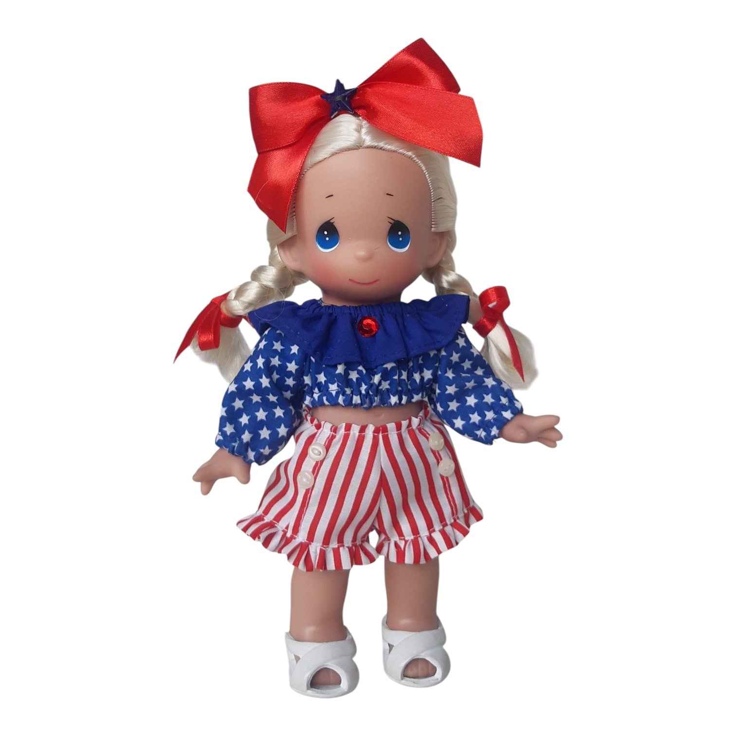 The Doll Maker 9-inch Precious Moments vinyl doll wearing a patriotic 4th of July outfit with red, white, and blue.