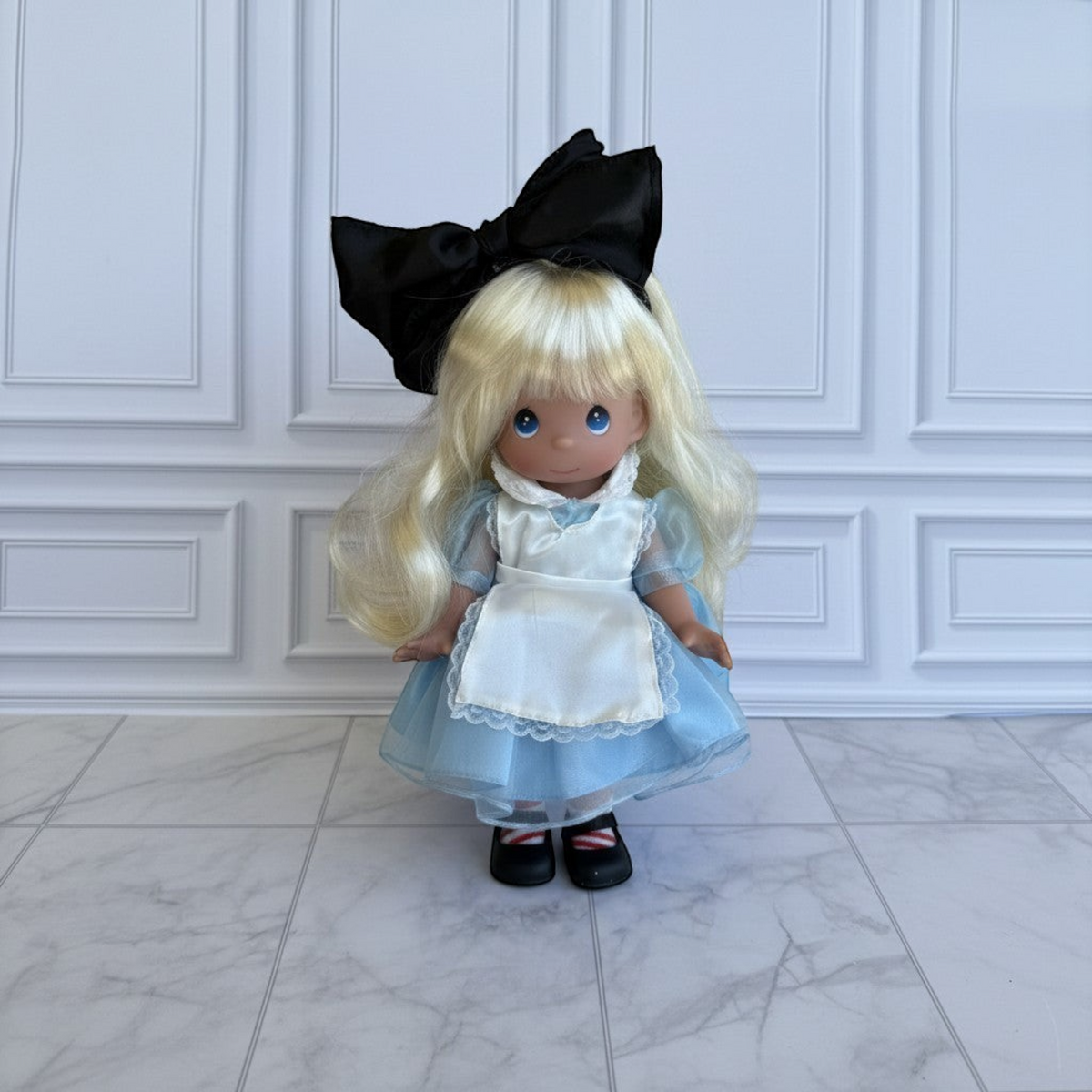 The Doll Maker 12-inch Alice in Wonderland doll with blonde hair, blue dress, white apron, and large black hair bow.