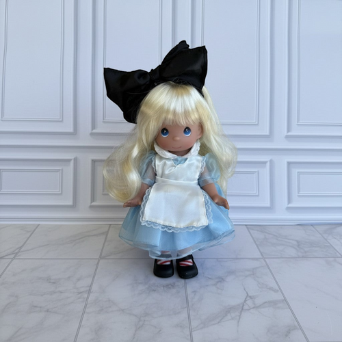 The Doll Maker 12-inch Alice in Wonderland doll with blonde hair, blue dress, white apron, and large black hair bow.