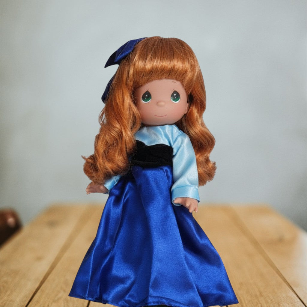 The Doll Maker 12-inch Kiss the Girl Ariel doll with long red hair wearing a shimmering blue gown and matching bow.
