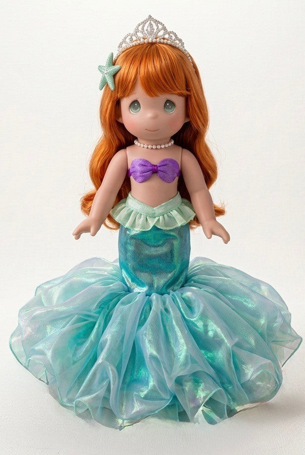 The Doll Maker 12-inch Ariel mermaid doll with red hair, a tiara, purple seashell top, and iridescent blue tail.