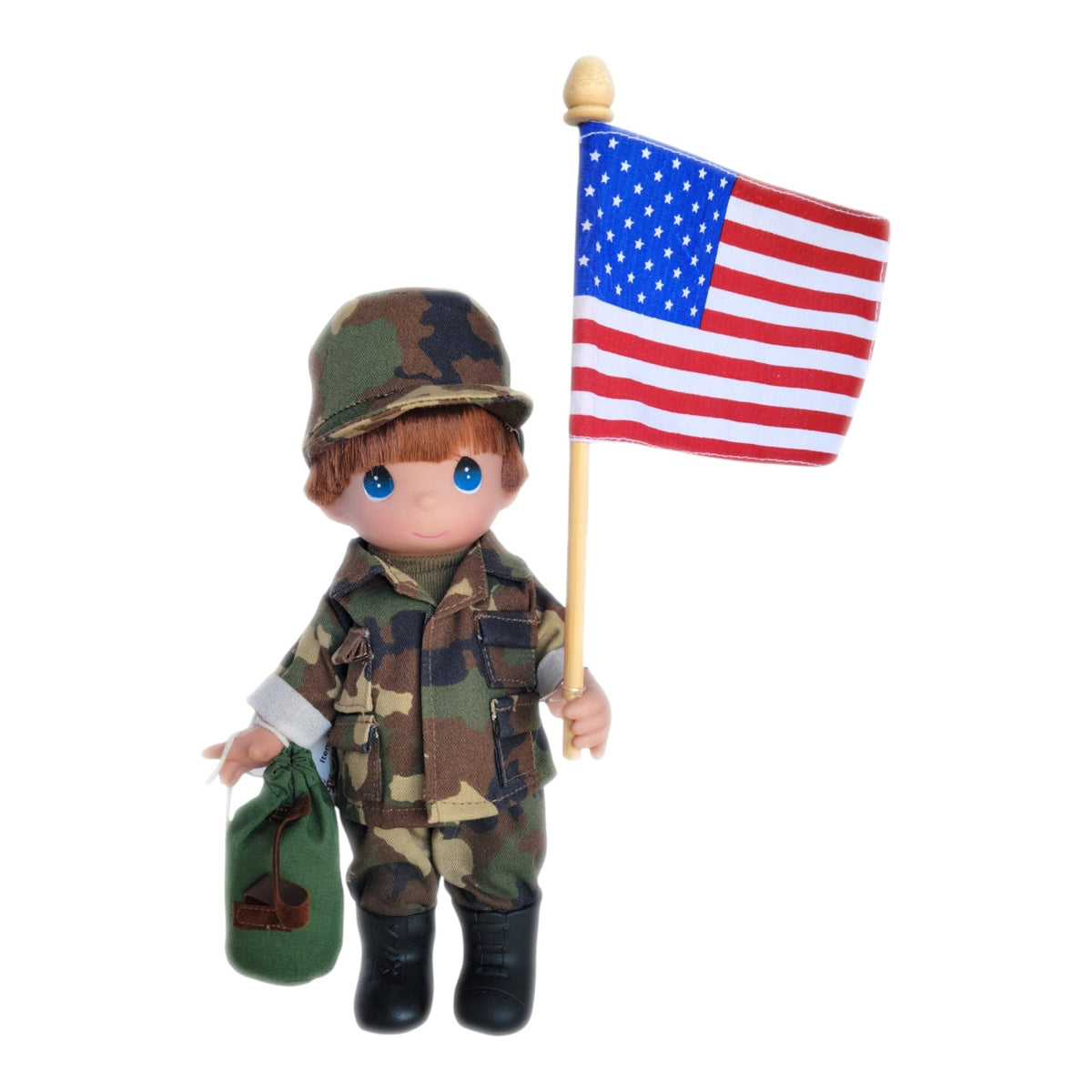 The Doll Maker 9-inch Army Boy vinyl doll wearing camouflage uniform and cap, holding a small American flag and bag.