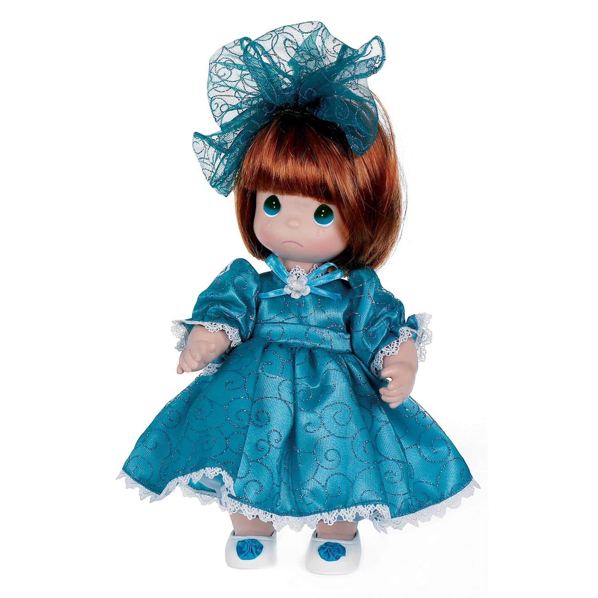 The Doll Maker I'm So Sorry Auburn 12-inch vinyl doll wearing a teal dress with glittery swirls and a matching bow.
