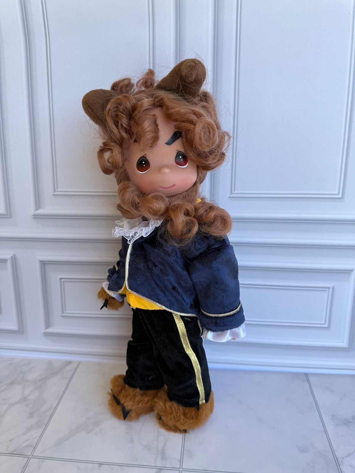 The Doll Maker 12-inch Beast doll with curly brown hair, wearing a blue velvet jacket and black trousers.