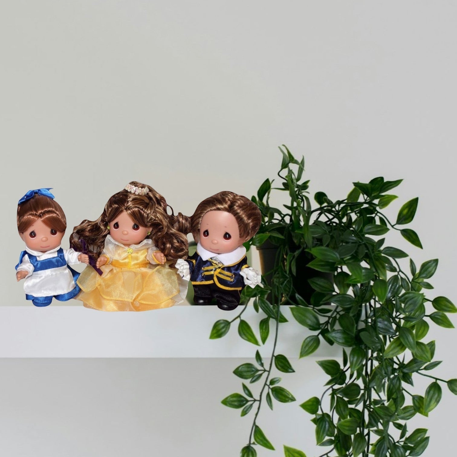 The Doll Maker 3-piece Beauty and the Beast doll set featuring Belle in yellow and blue dresses and the Beast.