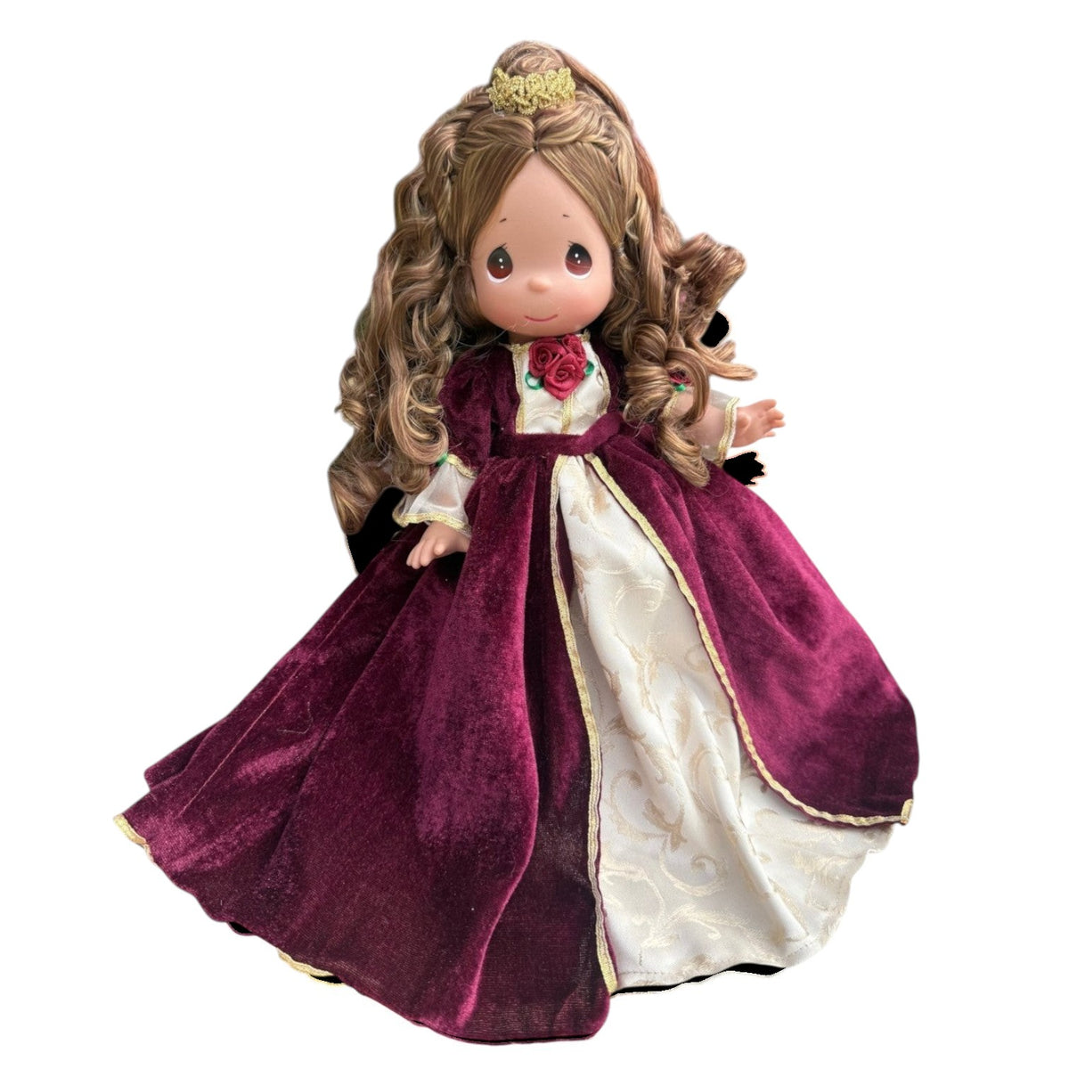 The Doll Maker 12-inch Belle doll wearing a burgundy velvet Christmas dress with gold trim and a small gold crown.