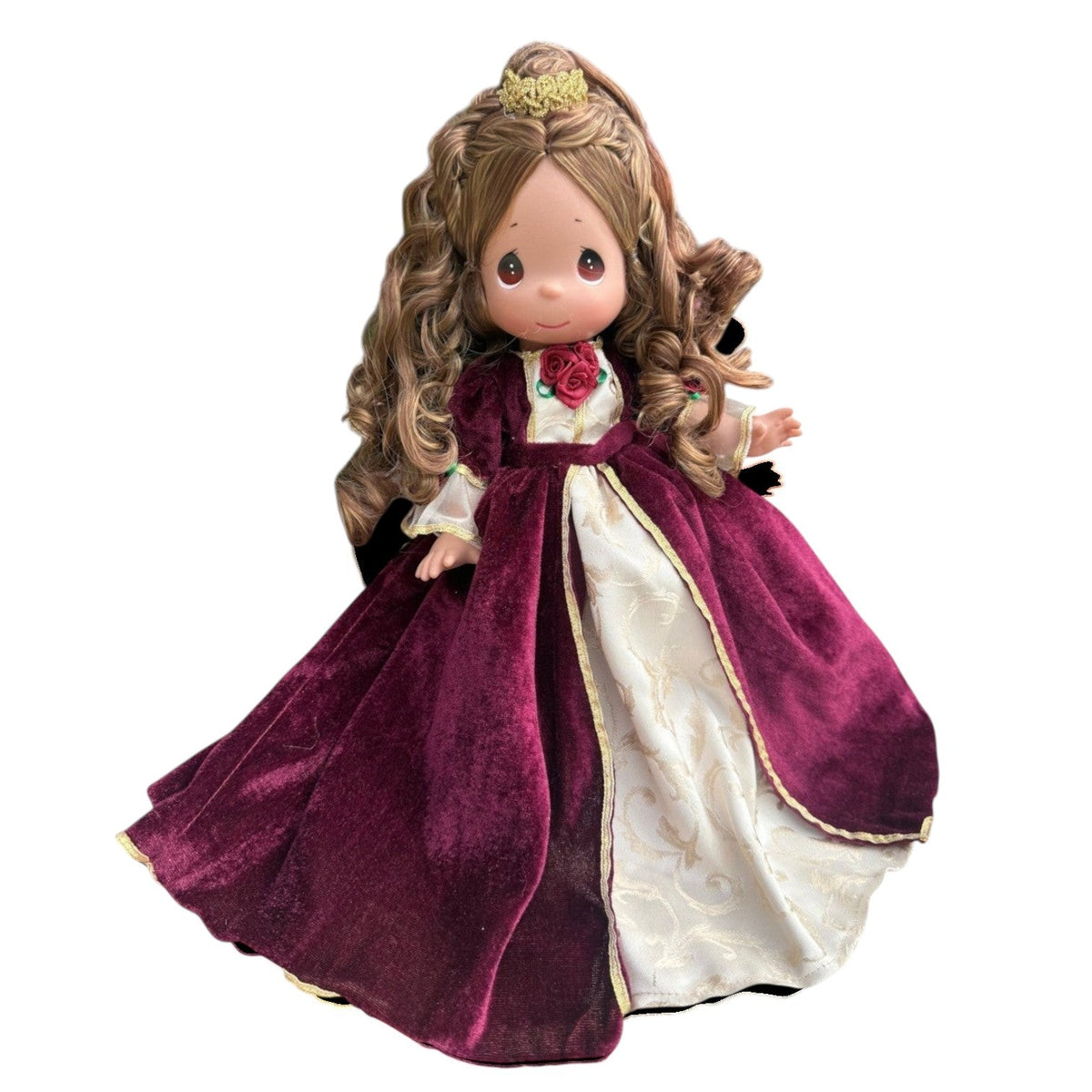 The Doll Maker 12-inch Belle doll wearing a burgundy velvet Christmas dress with gold trim and a small gold crown.