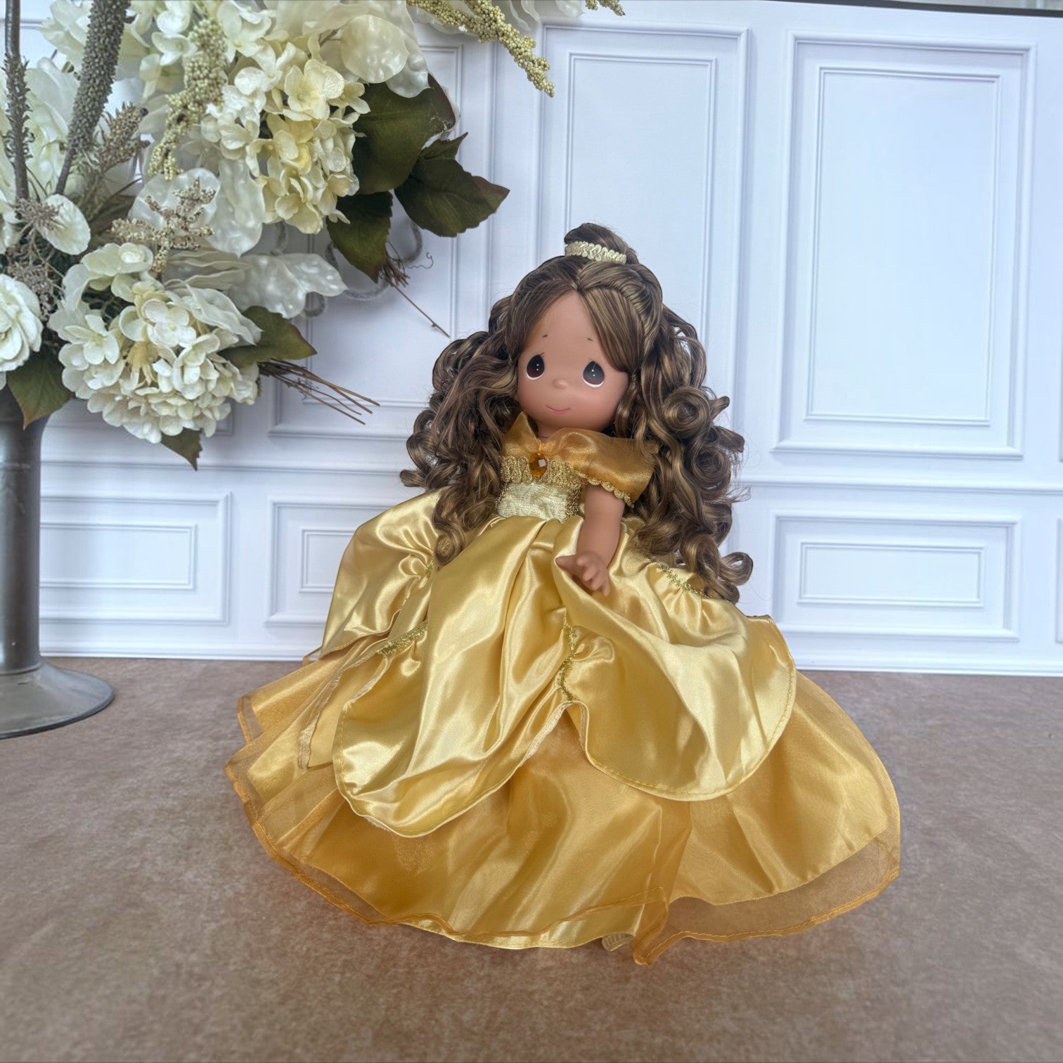 The Doll Maker 12-inch Belle doll with long curly brown hair wearing an elegant gold satin ball gown