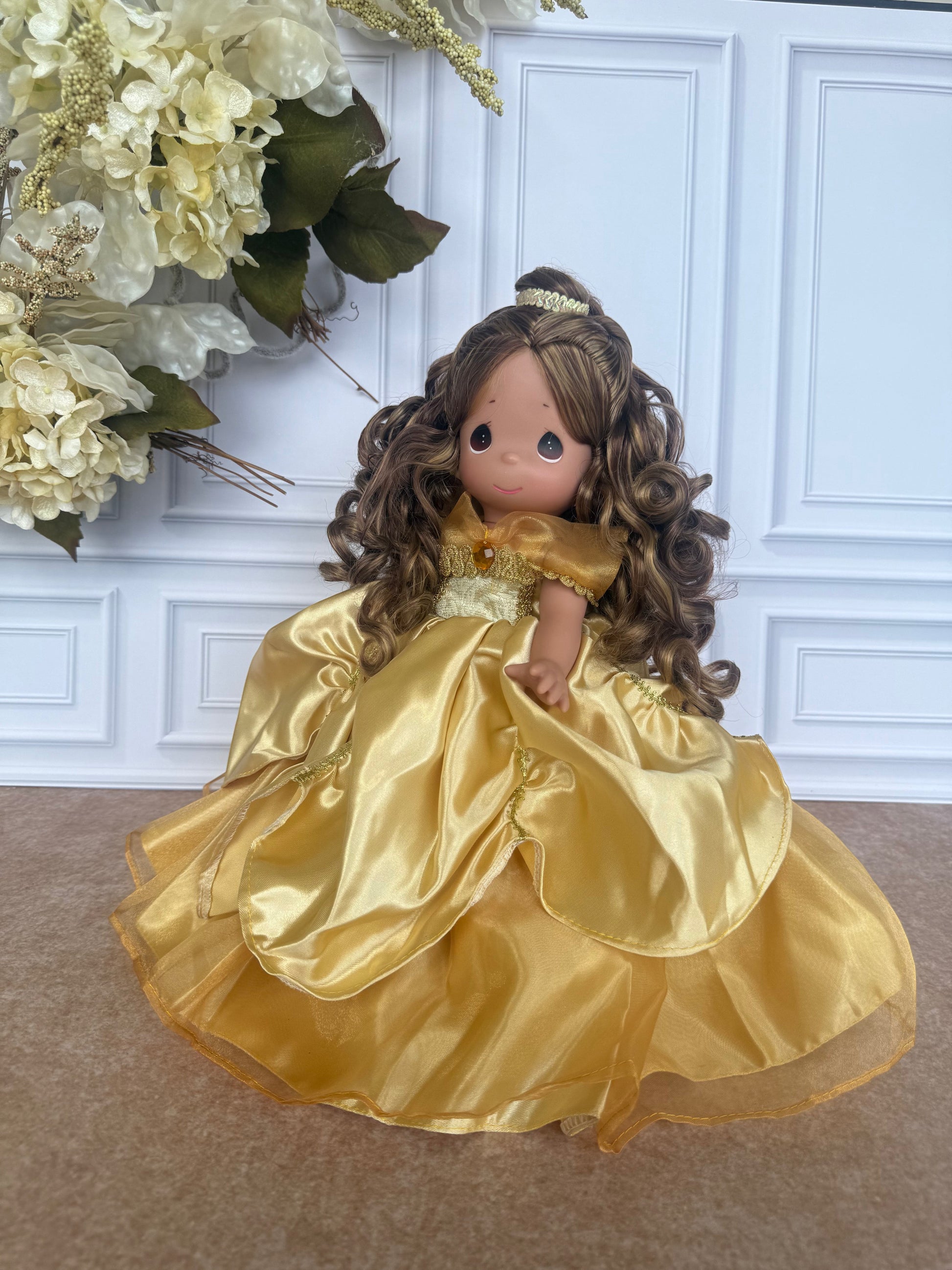 The Doll Maker 12-inch Belle doll with long curly brown hair wearing an elegant gold satin ball gown