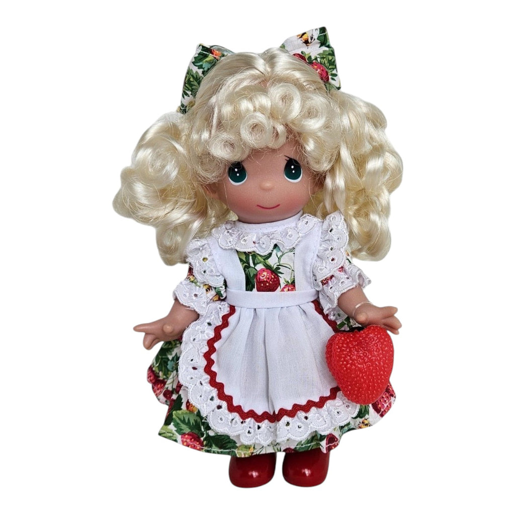 The Doll Maker You’re Berry Sweet 9-inch vinyl doll with blonde curls, strawberry print dress, and white apron.