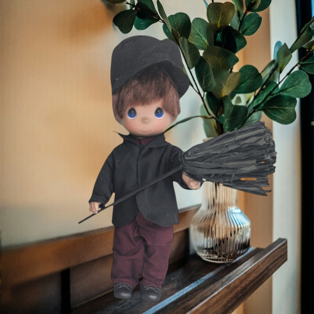 The Doll Maker 12-inch Bert chimney sweep doll from Mary Poppins wearing a black jacket, cap, and dark trousers.