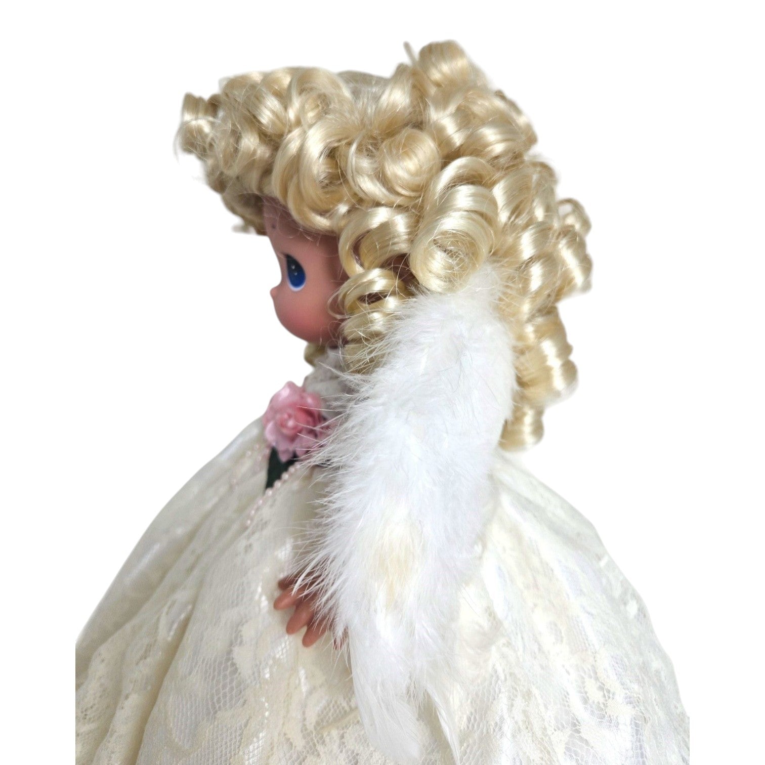 The Doll Maker 12-inch blonde angel doll wearing a white lace dress with feathered wings, side profile view.