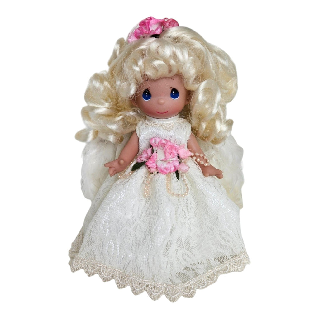 The Doll Maker 7-inch blonde angel doll wearing a white lace dress with pink floral accents and pearl details.