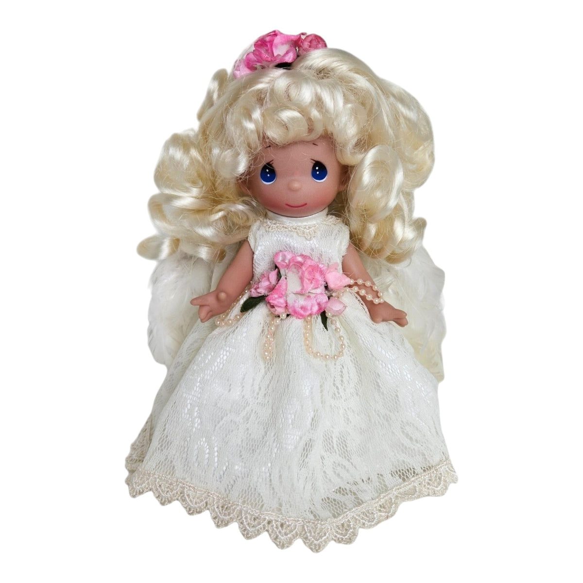 The Doll Maker 7-inch blonde angel doll wearing a white lace dress with pink floral accents and pearl details.
