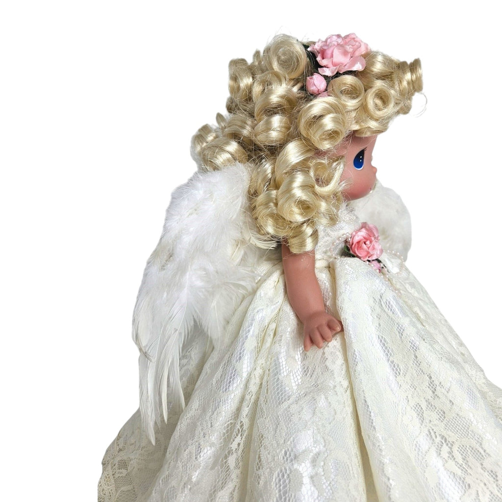 The Doll Maker 12-inch blonde angel doll wearing a white lace dress with feathered wings and pink floral accents