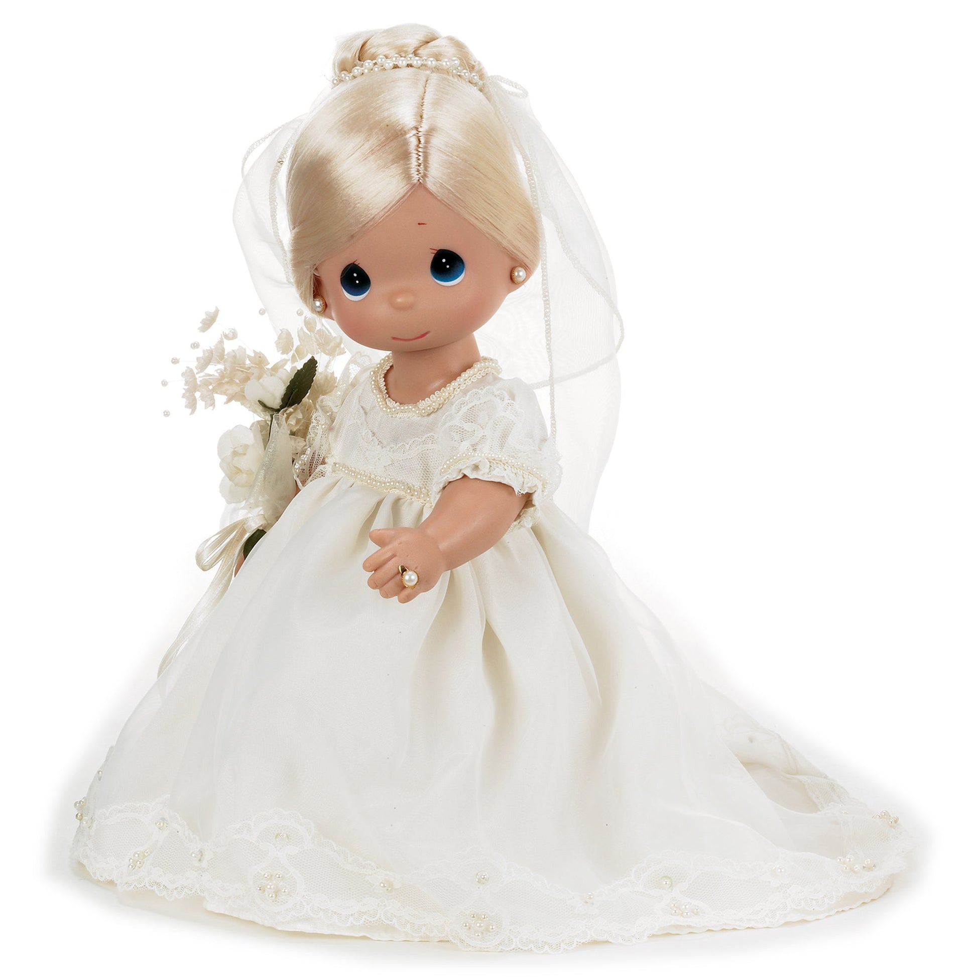 The Doll Maker Enchanted Dreams blonde bride doll wearing a white lace wedding gown with a veil and holding flowers.