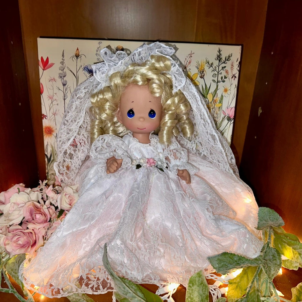 The Doll Maker Fairytale Come True blonde bride doll wearing a white lace wedding dress and veil with floral accents.