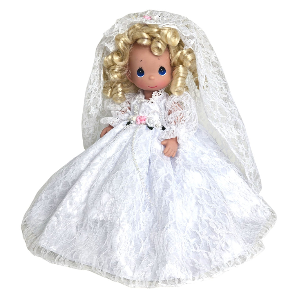 The Doll Maker Fairytale Come True blonde bride doll wearing a white lace wedding dress and veil with floral accents.