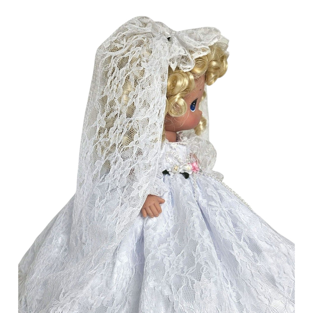 The Doll Maker Fairytale Come True blonde bride doll wearing a white lace wedding dress and veil, side profile view.