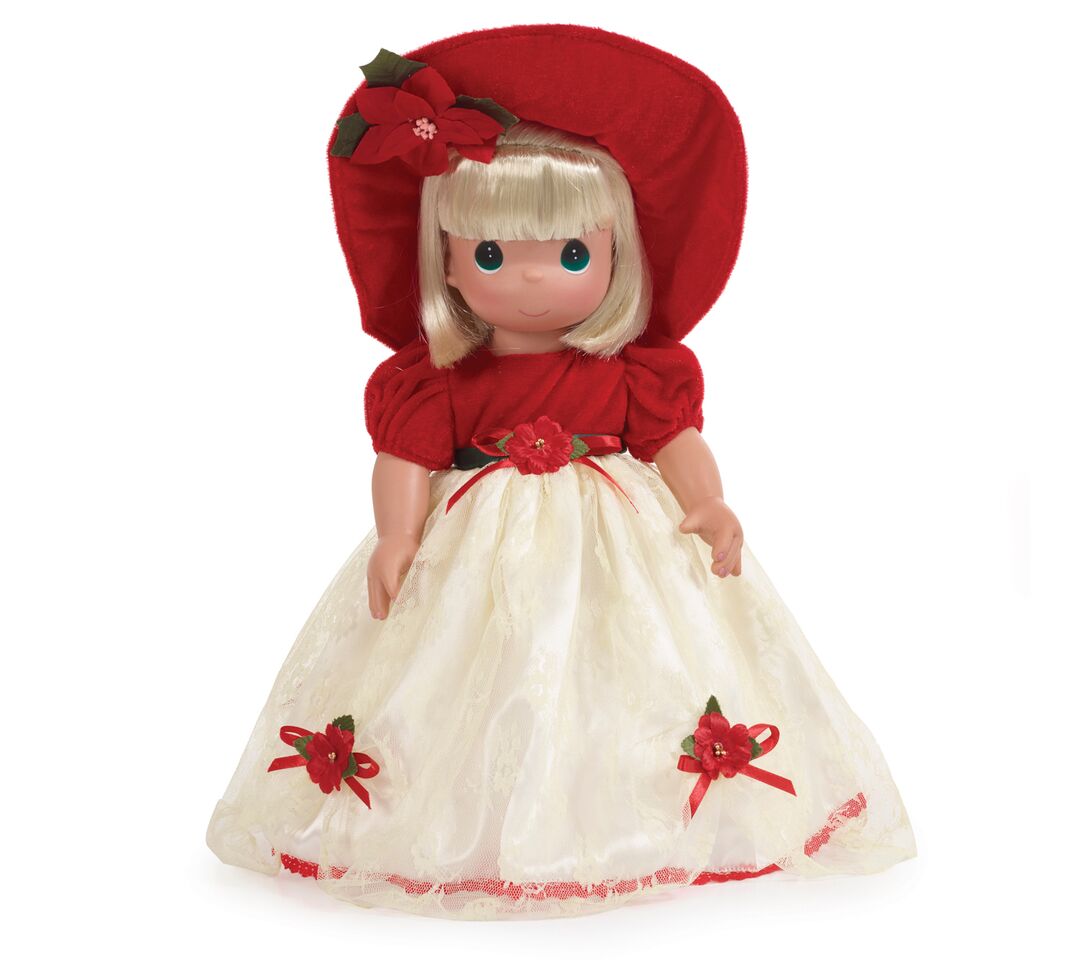 The Doll Maker 16 inch blonde vinyl Christmas doll wearing a red velvet hat and cream lace dress with floral accents.