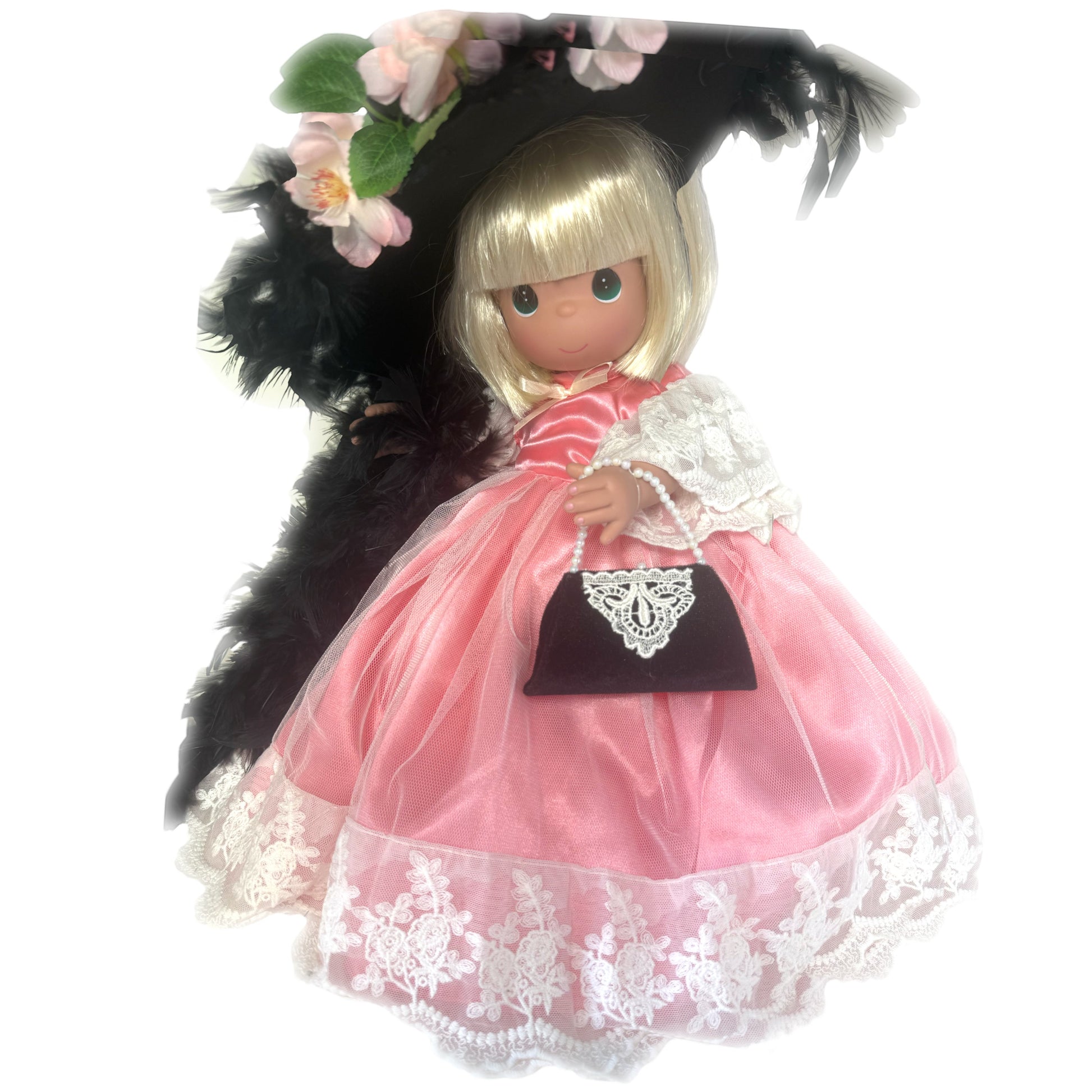 The Doll Maker Cherished Memories 16-inch blonde doll wearing a pink satin dress with lace and a black feathered hat.