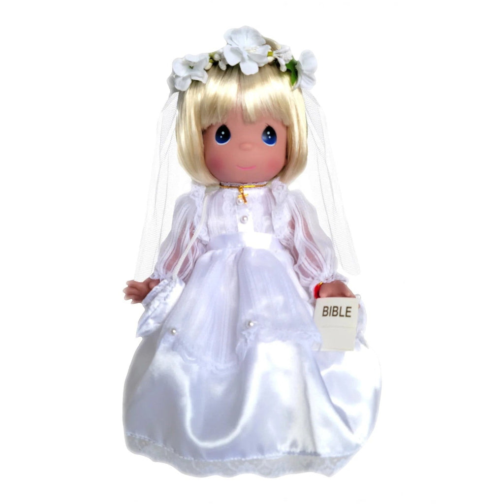 The Doll Maker 12-inch blonde First Communion vinyl doll wearing a white satin gown, veil, flower crown, and cross.