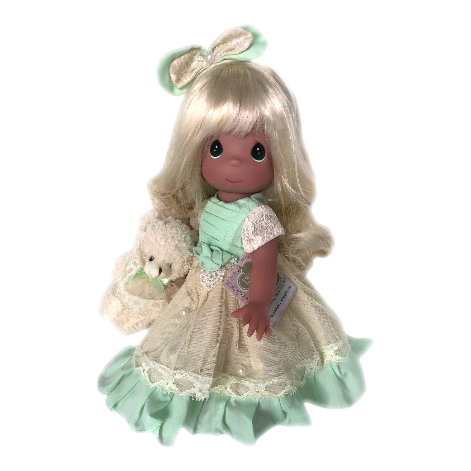 The Doll Maker 12-inch blonde doll wearing an ivory and green lace dress with a matching hair bow and plush bear