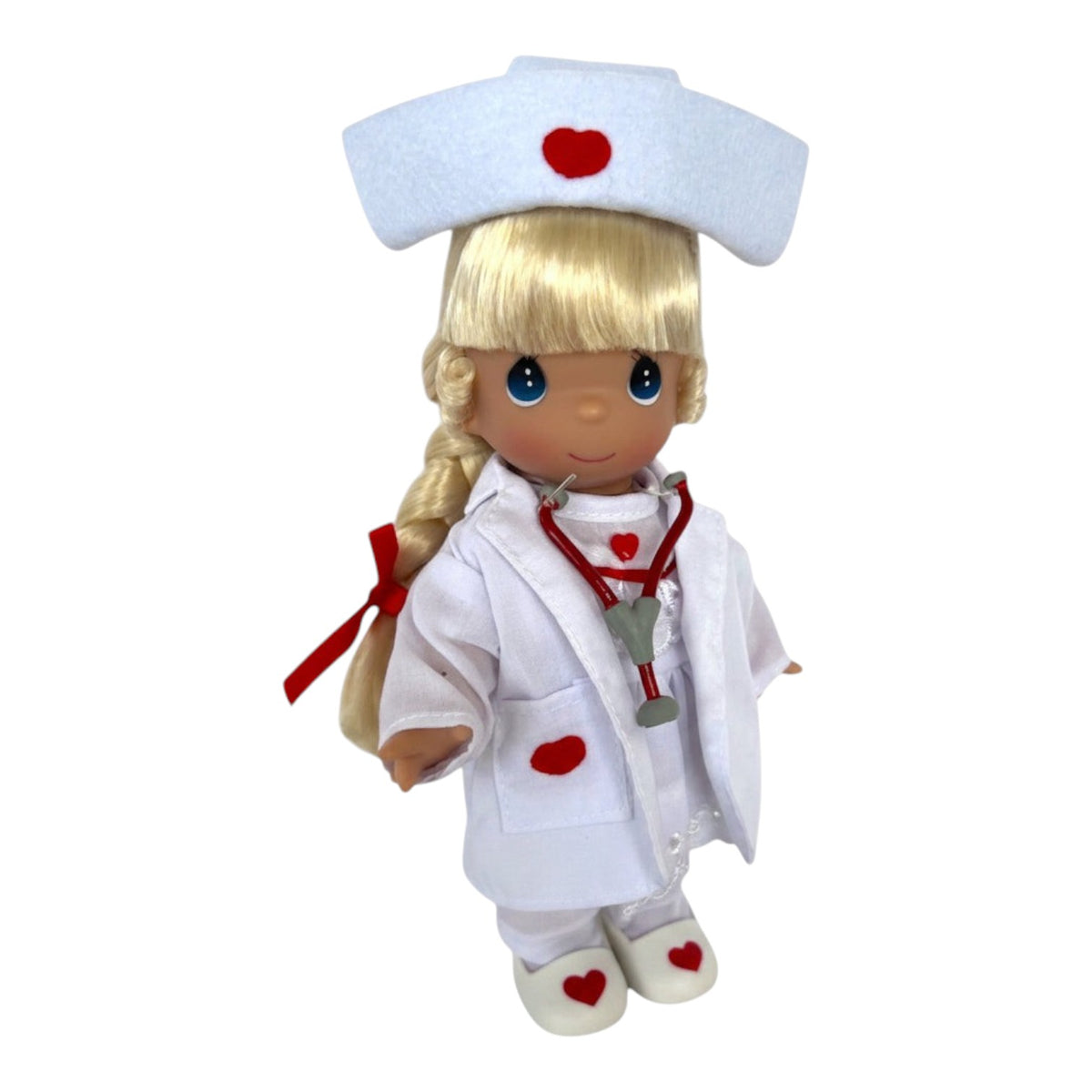 The Doll Maker Loving Touch blonde nurse doll wearing a white uniform with red heart accents and a stethoscope.