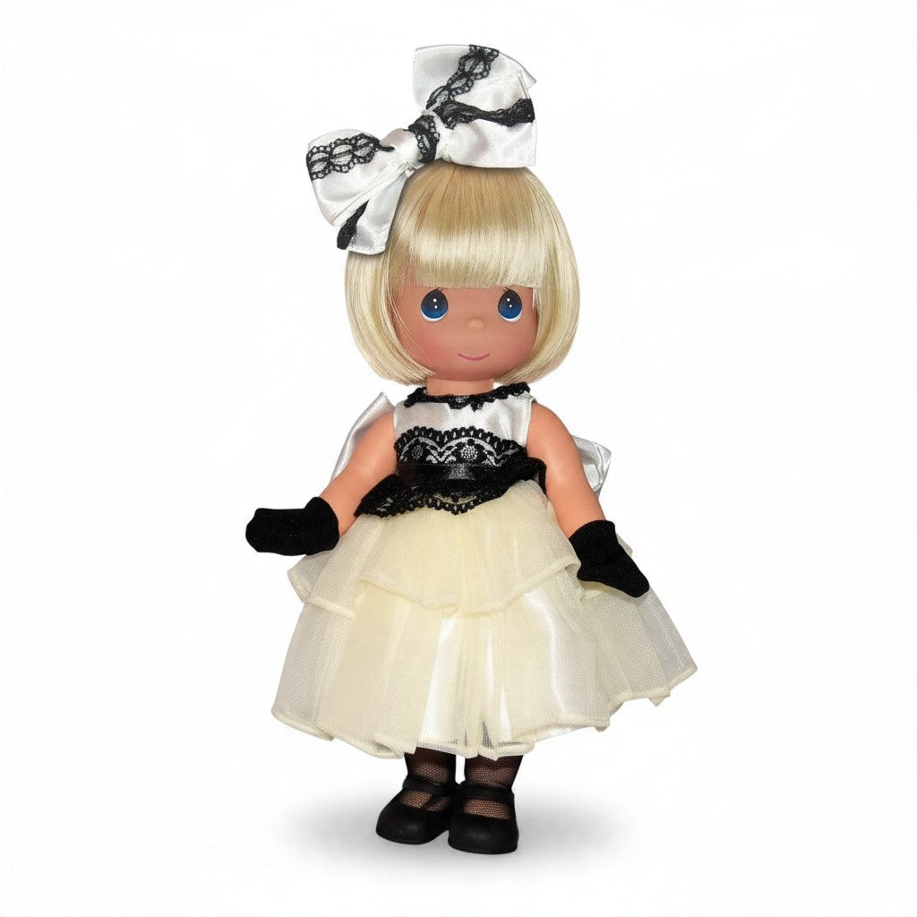 The Doll Maker 12-inch blonde vinyl doll wearing a sophisticated white and black gown with a matching hair bow.