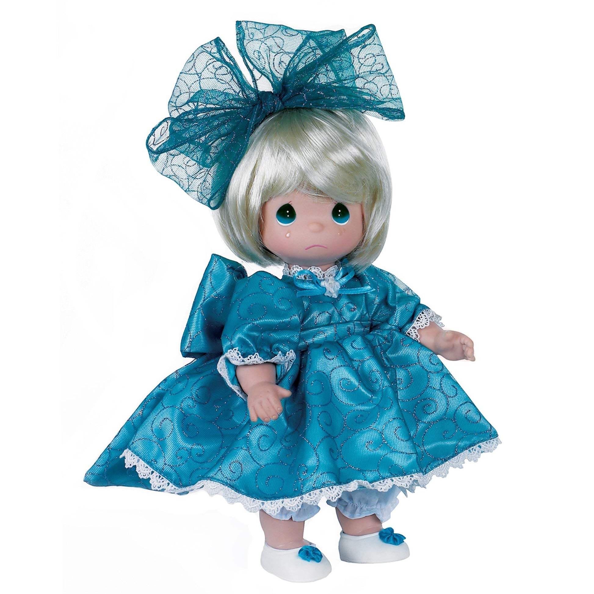The Doll Maker I'm So Sorry blonde vinyl doll wearing a teal dress with glittery swirls and a matching hair bow.