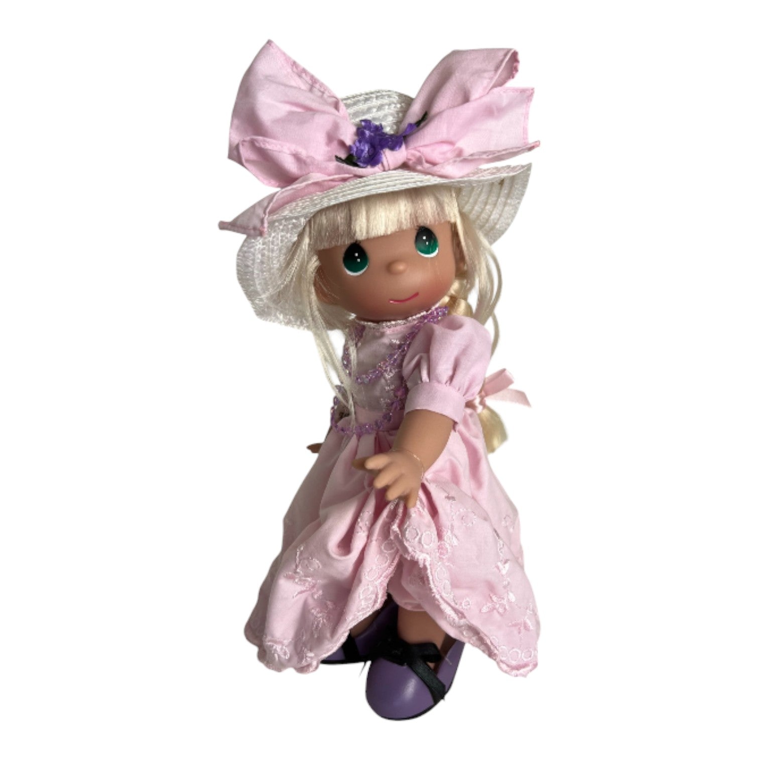 The Doll Maker 12-inch blonde Precious Moments doll wearing a pink dress, pink necklace, and over sized purple shoes.