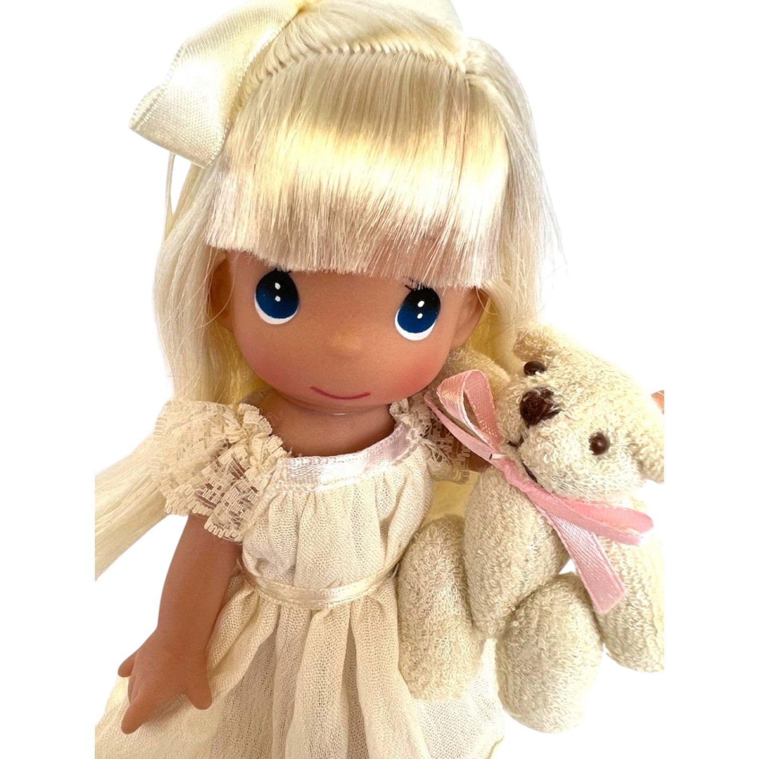 The Doll Maker 7-inch blonde vinyl doll wearing an ivory lace gown and holding a small teddy bear with a pink ribbon.