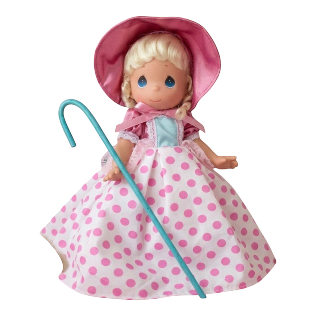 The Doll Maker 12-inch Bo Peep doll from Toy Story wearing a pink bonnet and a white dress with pink polka dots.