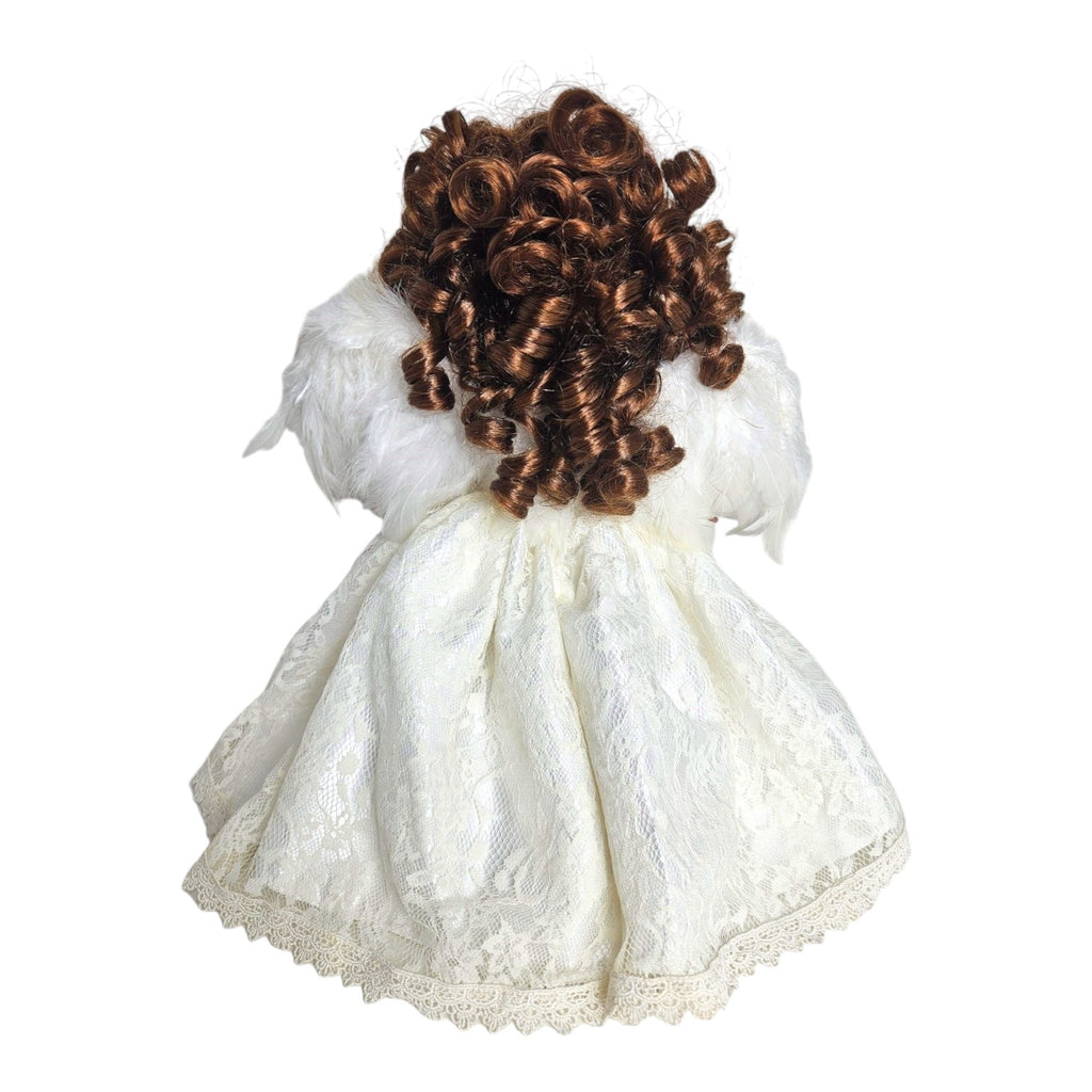 The Doll Maker 12-inch brunette angel doll wearing a white lace dress with feathered wings, back view.