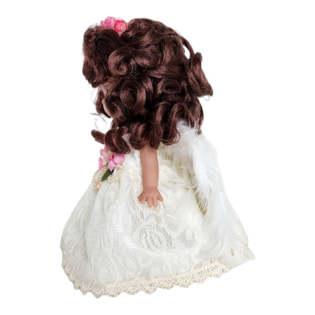 The Doll Maker 7-inch brunette angel doll wearing a white lace dress with pink flowers and feathered wings, side view