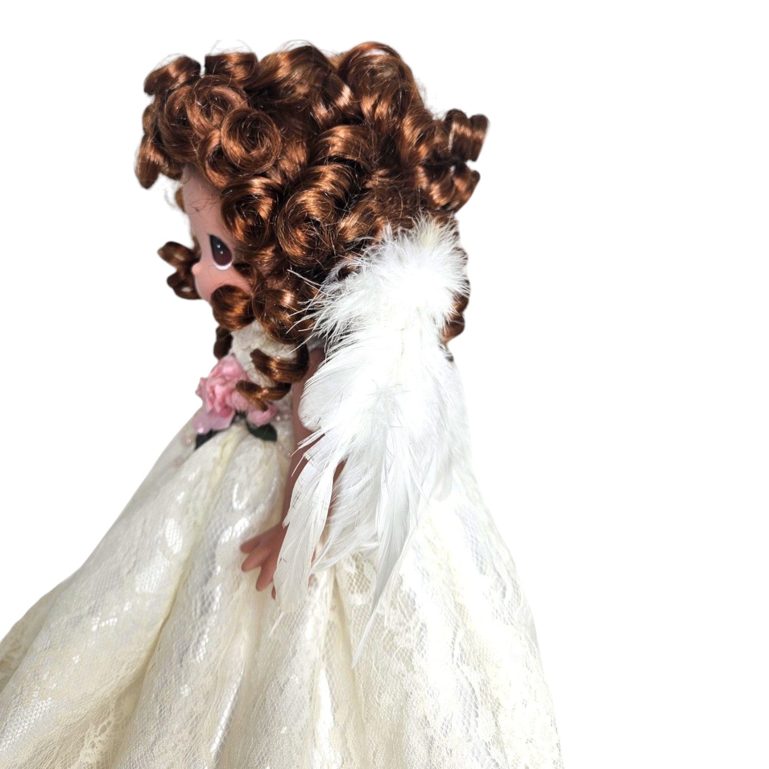 The Doll Maker 12-inch brunette angel doll wearing a white lace dress with delicate feathered wings, side profile view.