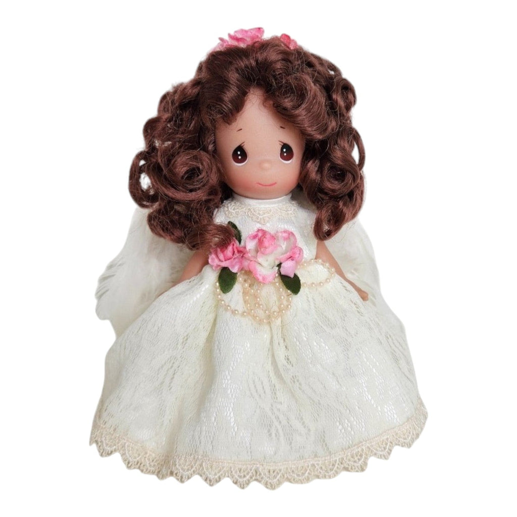 The Doll Maker 7-inch brunette angel doll wearing a white lace dress with pink flower accents and pearl details.