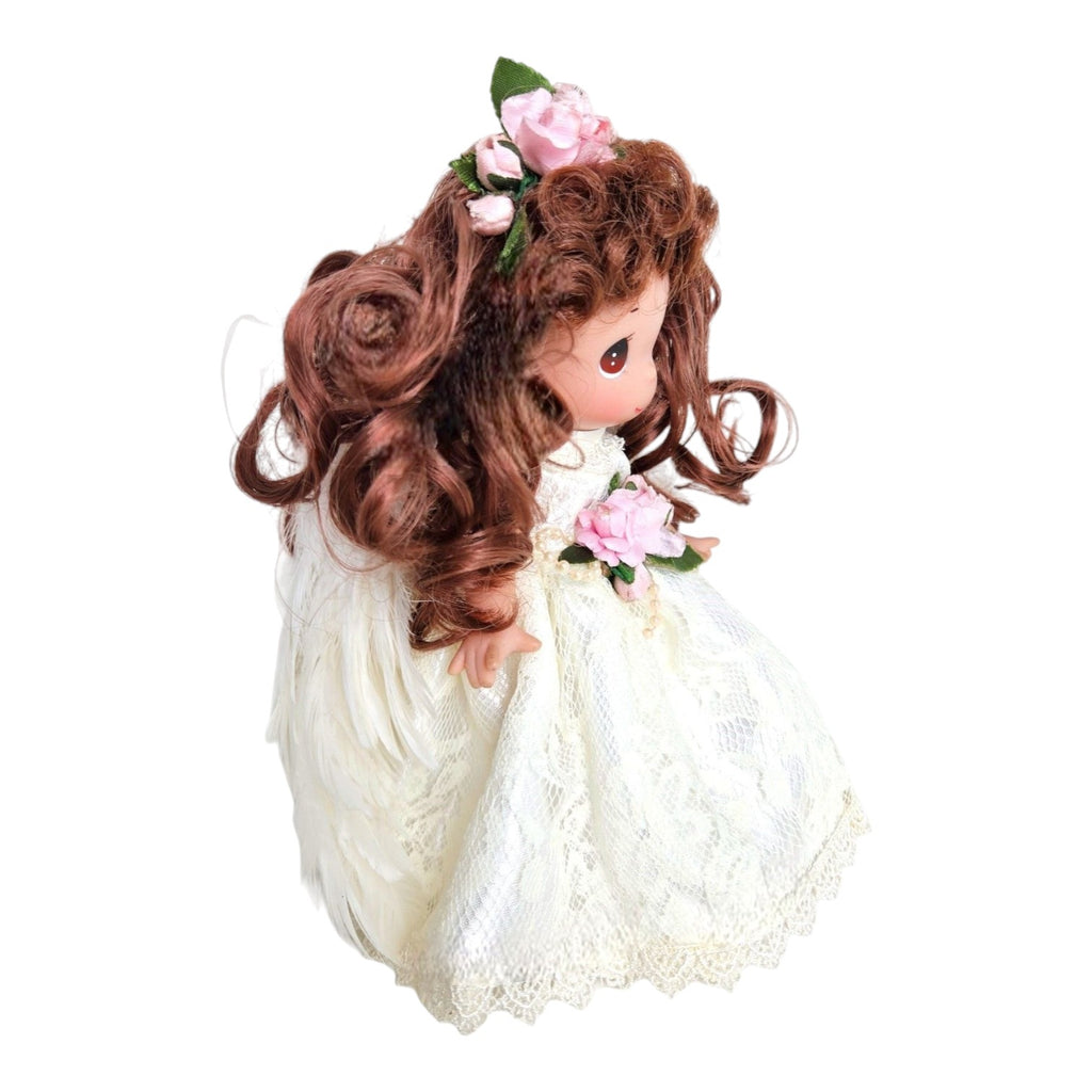 The Doll Maker 9-inch brunette angel doll wearing a white lace dress with feathered wings and pink floral accents.