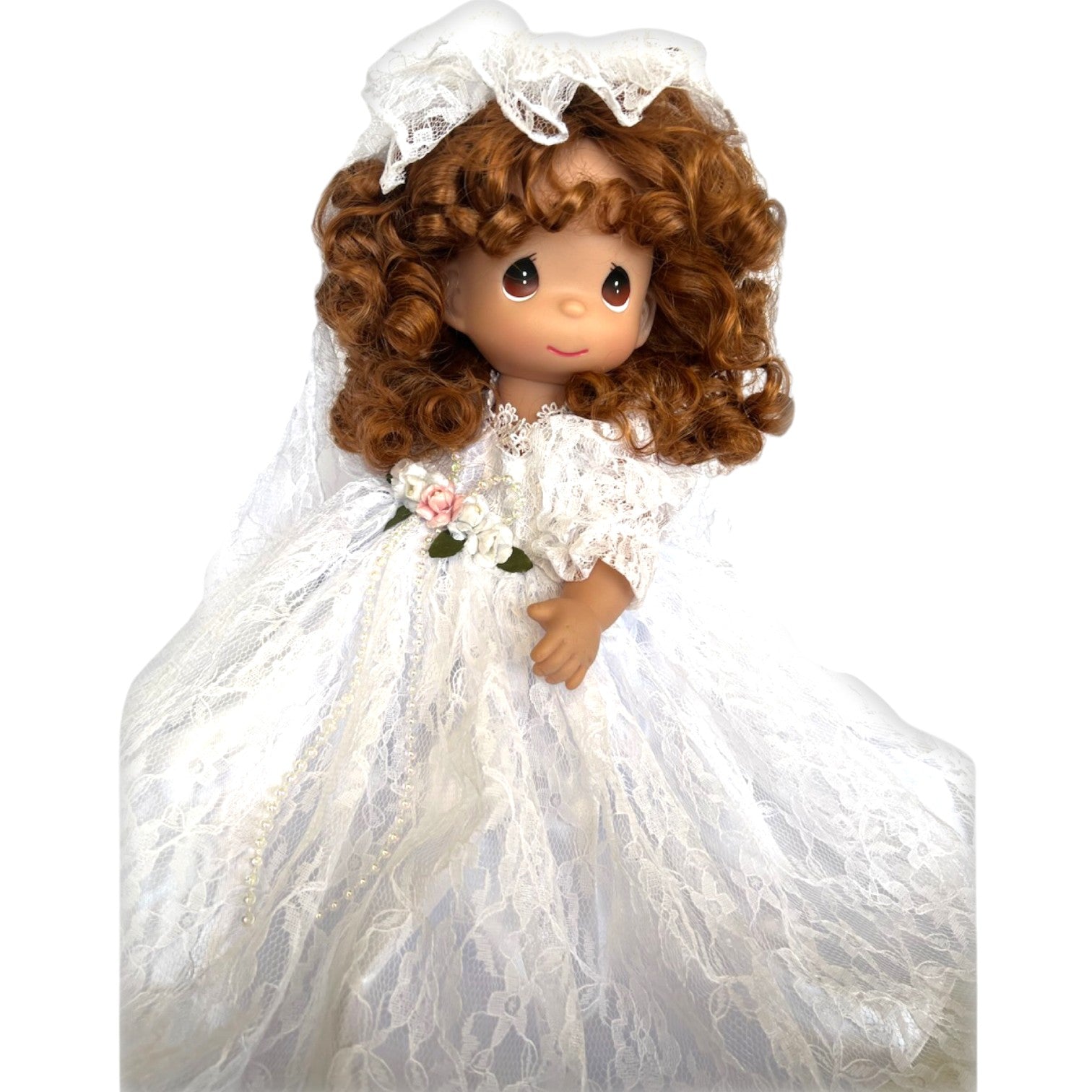 The Doll Maker 12-inch brunette bride doll wearing a white lace wedding dress with floral accents and a lace veil.