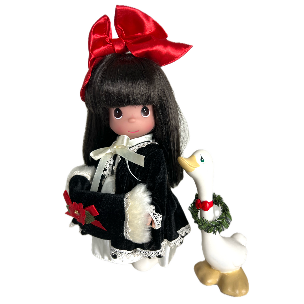 Precious Moments dolls designed by Linda Rick The Doll Maker 12-inch brunette Christmas doll wearing a black velvet coat with white fur trim and a large red bow.