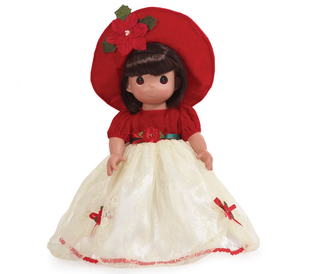 The Doll Maker 16-inch brunette vinyl Christmas doll wearing a red velvet hat and dress with a cream lace skirt.