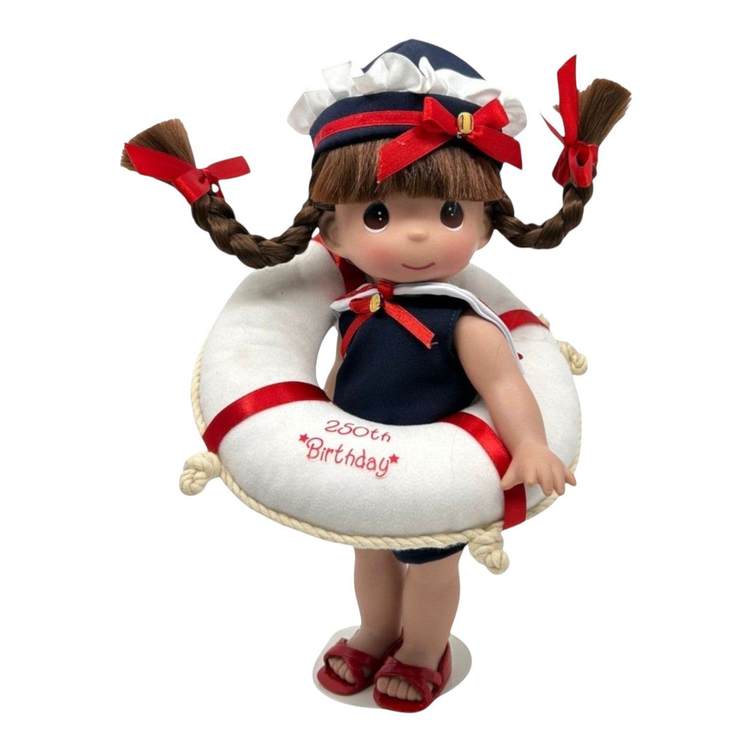The Doll Maker 12-inch brunette doll wearing a nautical outfit and holding a life saver for the USA 250th birthday.