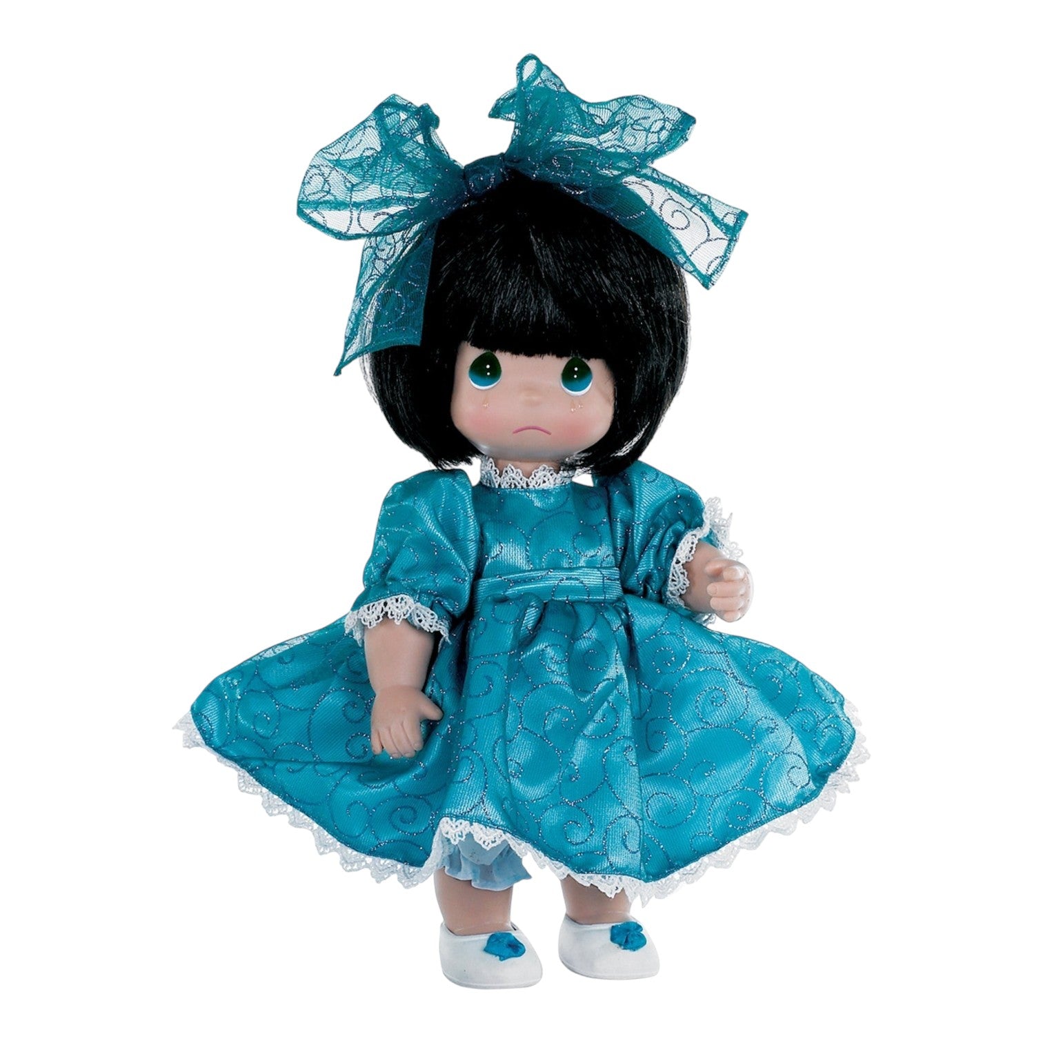 The Doll Maker 12-inch brunette vinyl doll wearing a teal dress with glittery swirls and a matching lace hair bow.