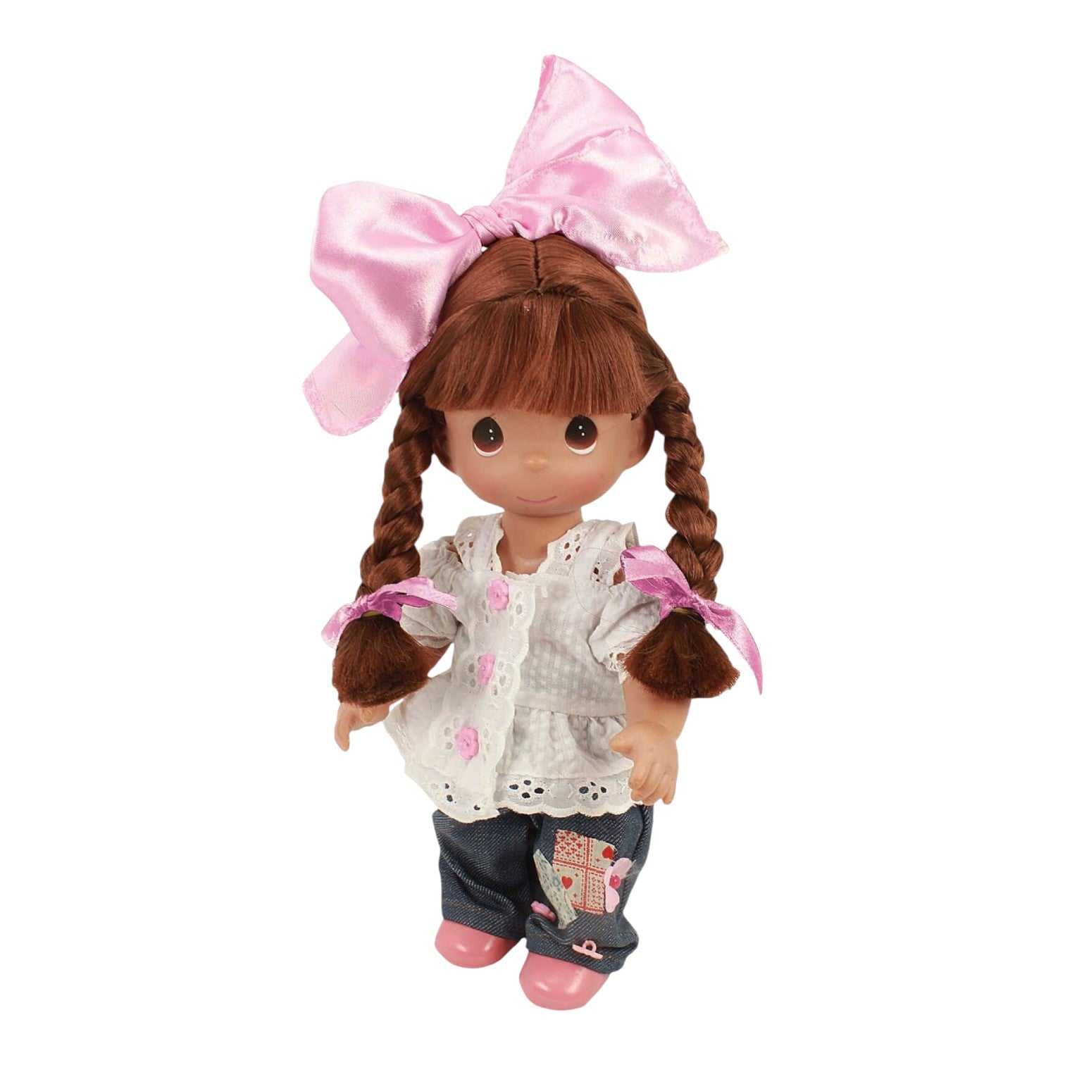 The Doll Maker Cute as a Button 12-inch brunette vinyl doll with braided hair, pink bow, white top, and denim jeans.