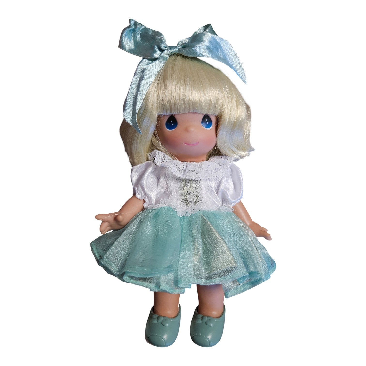 The Doll Maker Carolyn 9-inch collector doll with blonde hair, blue eyes, and a teal dress with a matching hair bow.