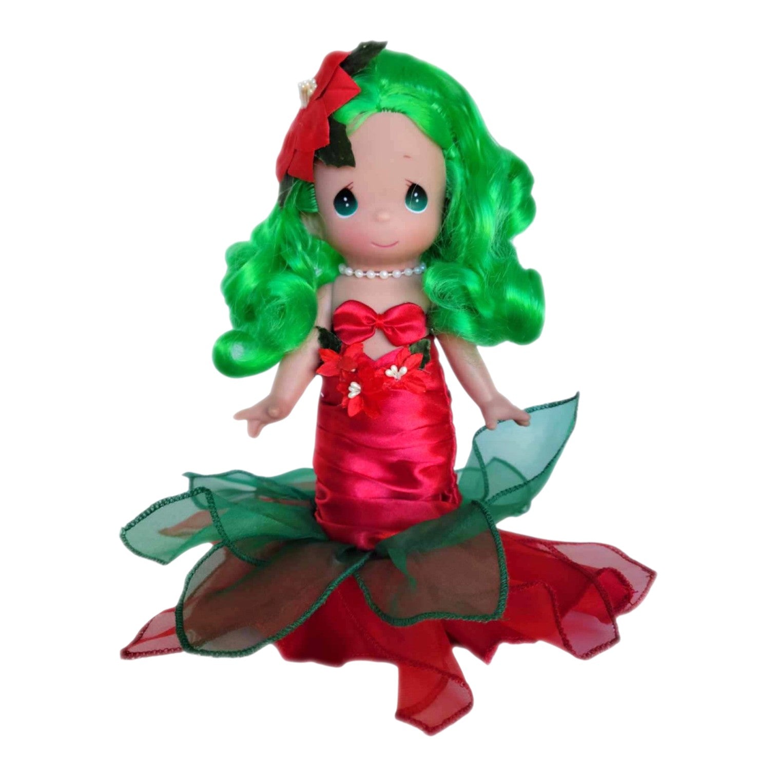 The Doll Maker 9-inch Christmas mermaid vinyl doll with bright green hair, red satin dress, and poinsettia accents.