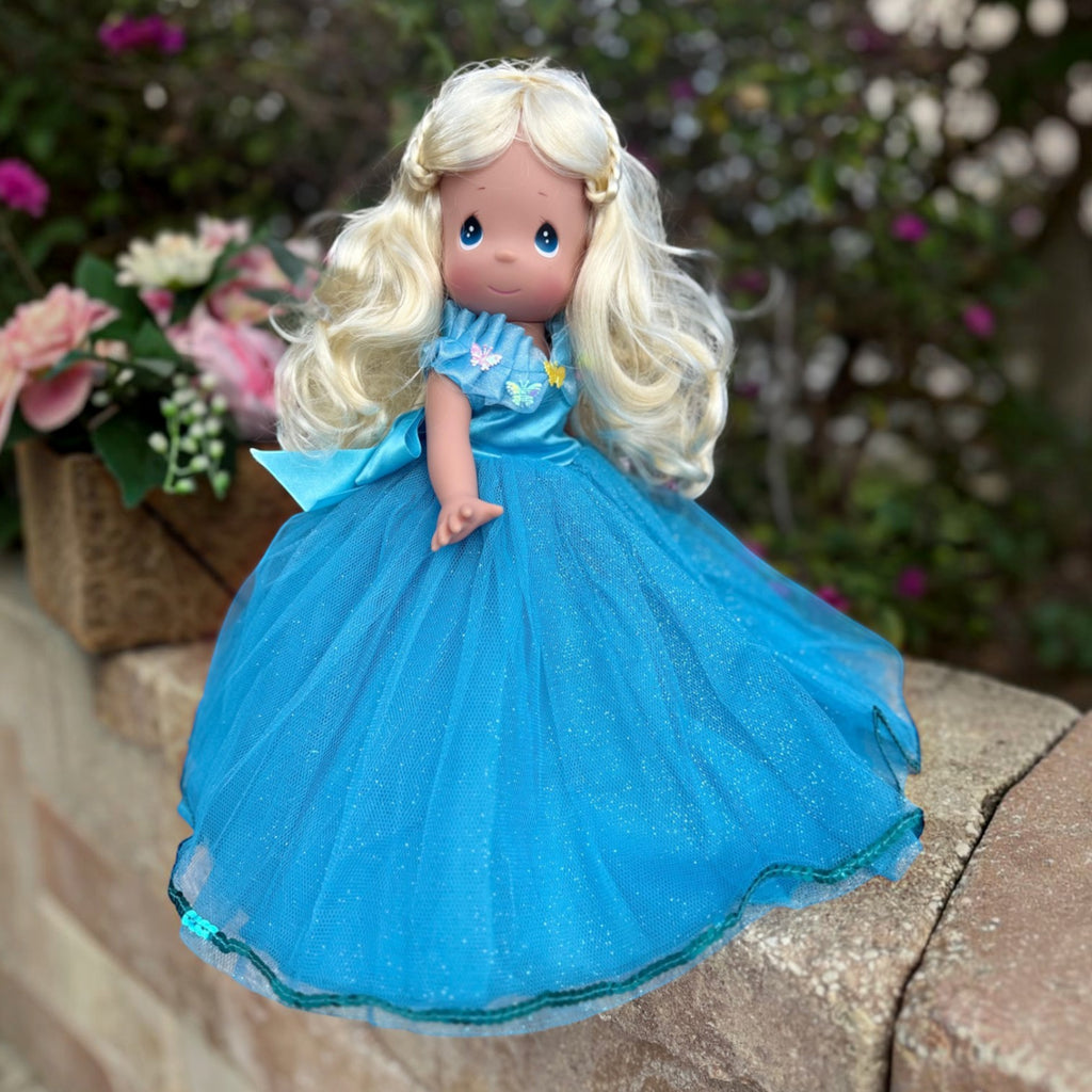 The Doll Maker 12-inch Cinderella doll with blonde hair wearing a blue tulle gown with butterfly accents.