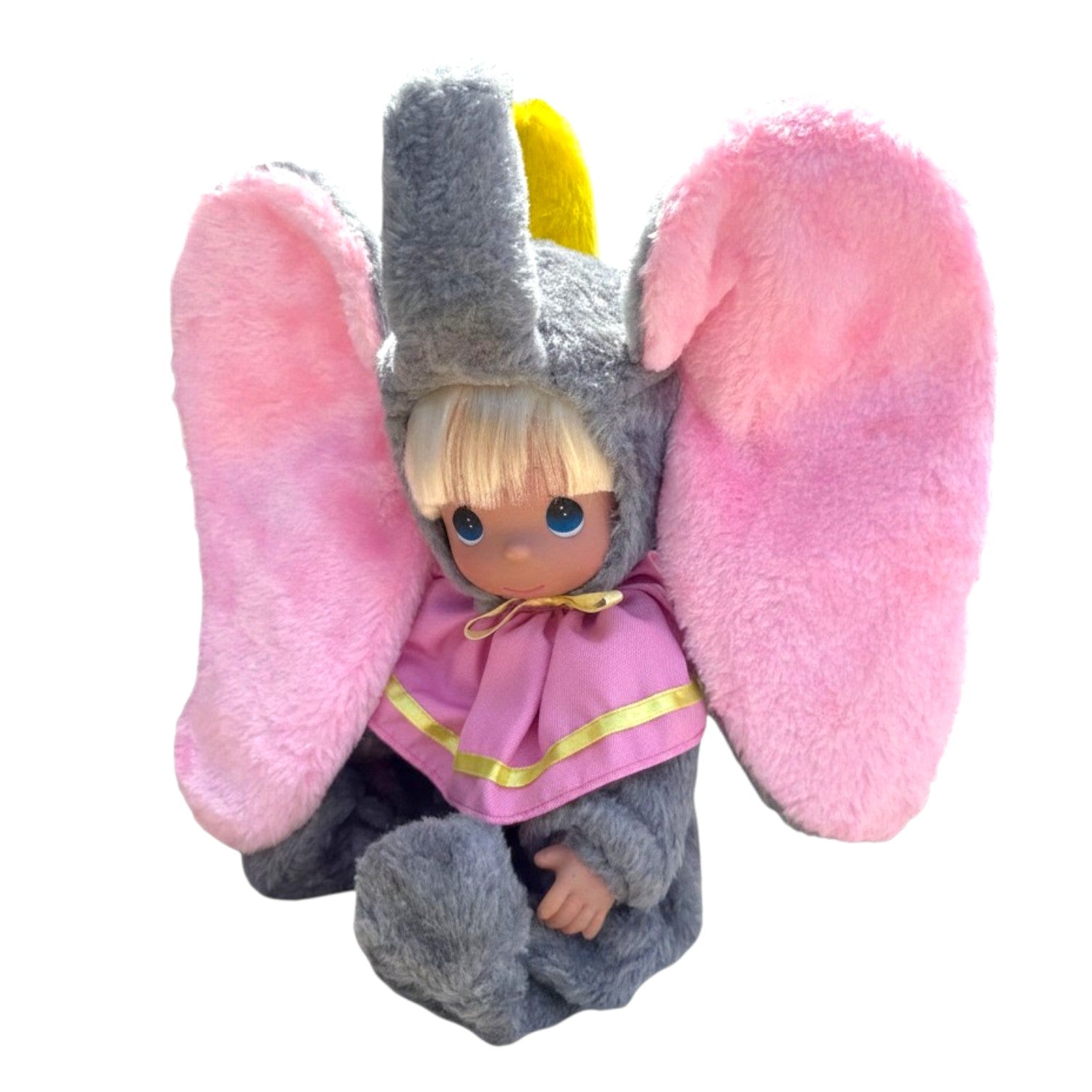 The Doll Maker Dumbo sitting doll with large pink plush ears, grey fuzzy elephant costume, and blonde hair